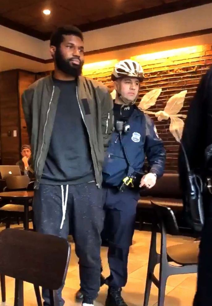 Police arresting two black men in Starbucks.