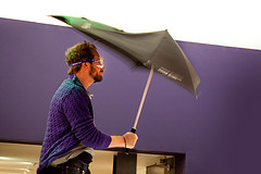 A man testing an umbrella in windy conditions.